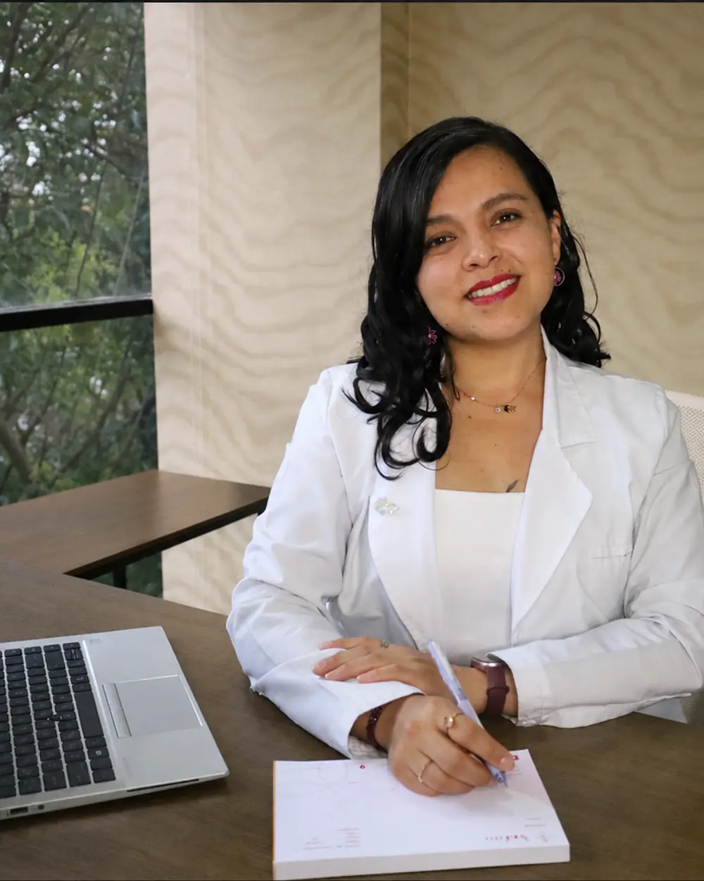 La Dra. Lidia Chávez tomando notas durante la consulta en Aurafem
